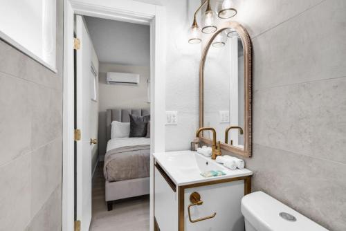 uma casa de banho com um lavatório, um espelho e uma cama em Relaxing Hollywood Pool Oasis em Hollywood