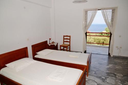 two beds in a room with a view of the ocean at Tiros Apartments Armonia in Tyros