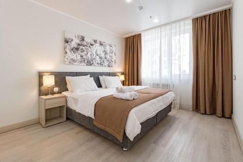 un dormitorio con una cama con un animal de peluche en Apart-hotel Ye,s Astana en Taldykolʼ
