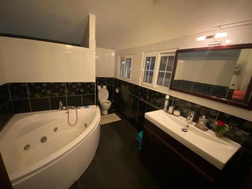a bathroom with a tub and a sink and a tub and a toilet at Serenity northen 6-beds villa with private pool in Grand-Baie