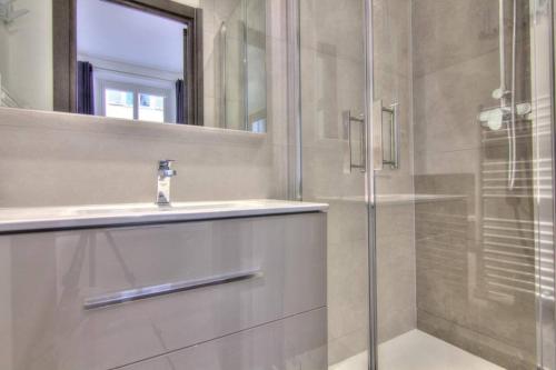 une salle de bain avec une douche, un lavabo et un miroir dans l'établissement Appartement Cannes 4 chambres - 5G, à Cannes