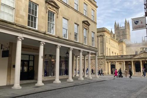 a building with columns and people walking in a street at Stunning Studio Flat w Picturesque View - Bath! in Bath