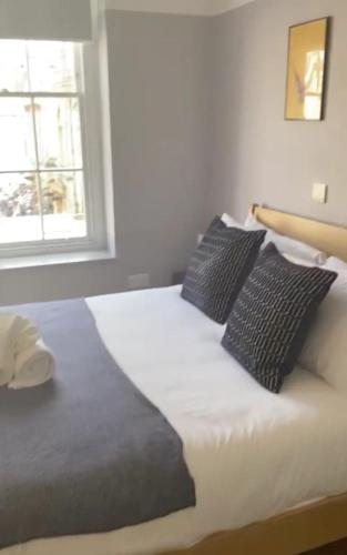 a bed with two pillows on it in a bedroom at Stunning Studio Flat w Picturesque View - Bath! in Bath