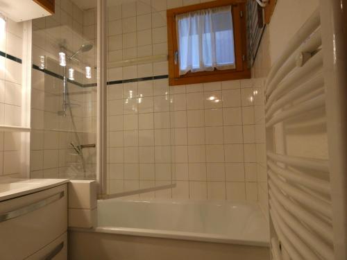 a white bathroom with a tub and a shower at Pied des pistes - Très bel appartement 4 personnes in Valmorel
