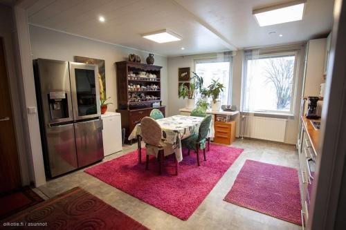 a kitchen with a table with chairs and a refrigerator at Viihtyisä ja rauhallinen keskustan tilava kaksio in Turku