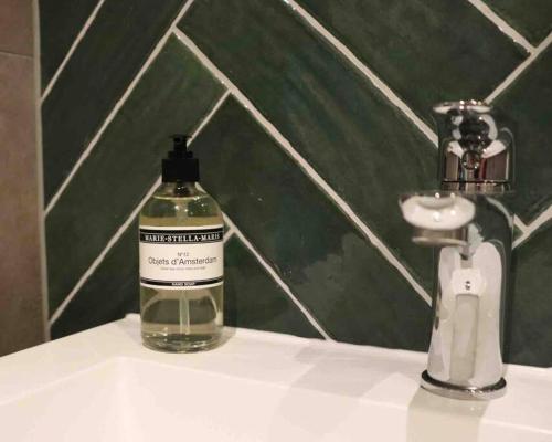 - une bouteille de savon assise sur un lavabo dans l'établissement GeinLust B&B De Zonnebloem, à Abcoude