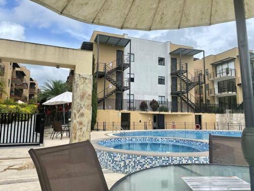 a swimming pool in front of a building at Reserva Quindiana in La Tebaida