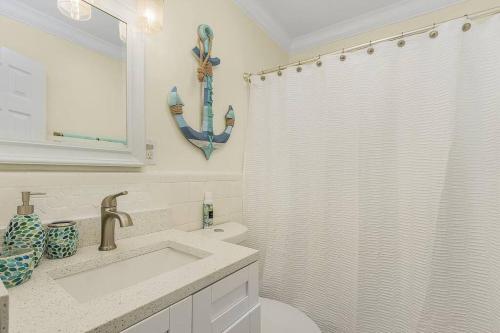 a bathroom with a sink and a shower curtain at Lake Park, 5 O’Clock Somewhere! in Naples