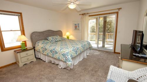 a bedroom with a bed and a window at Oceanside, Hot Tub, Close to beach, Community Pool, CP5, Easy Breezes in Corolla