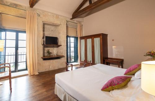 1 dormitorio con 1 cama blanca grande con almohadas rosas en Rectoral de Cobres 1729, en San Adrián de Cobres