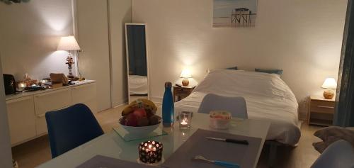 Cette petite chambre comprend un lit et une table. dans l'établissement Grand studio chaleureux à Port Neuf, à La Rochelle