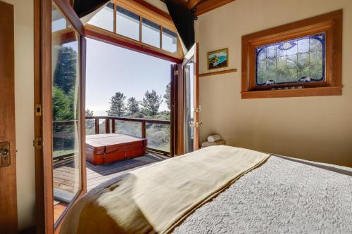 a bedroom with a bed and a balcony with a window at Romantic Ridgetop Escape with Hot Tub Near Mendocino in Albion