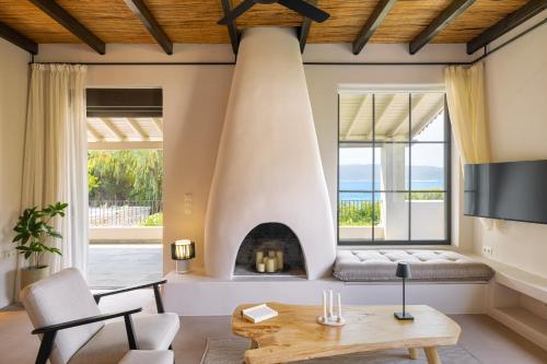 a living room with a fireplace and a table at Chariclea Villas Retreat in Samos