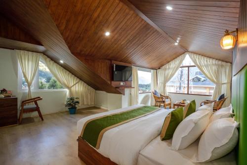 a bedroom with a large bed with a wooden ceiling at Tripli Hotels Drilbu Manali in Manāli