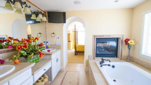 a bathroom with a tub and a sink and a fireplace at OCEANFRONT, 18 BRs, ELEV, Theater, Rec Room, Poolside Bar, Luxury, EP204, Grande Ritz Carolina in Kill Devil Hills