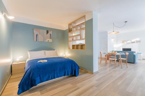 a bedroom with a blue bed and a dining room at Cascina 6b in San Maurizio Canavese