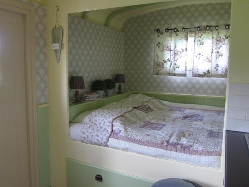 um quarto com uma cama e uma janela em Pipowagen Minicamping De Linde em Merselo