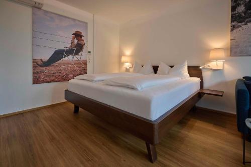 um quarto com uma cama com um quadro na parede em Design Studio Bergisel em Bregenz