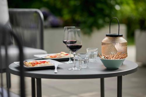 uma mesa com dois pratos de comida e um copo de vinho em Design Studio Bergisel em Bregenz