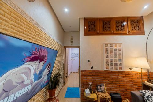 una sala de estar con una gran pintura en la pared en FIFI maison, en Ouarzazate
