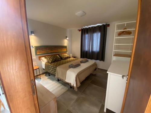 1 dormitorio con cama y ventana en Bungalow GOA Pool view, Playa Roca residence sea front access - Free AC - Wifi en Costa Teguise