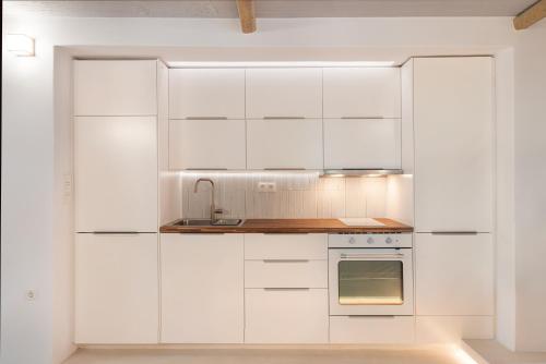 a white kitchen with white cabinets and a stove at Chariclea Villa in Samos