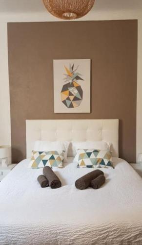 - un lit blanc avec 2 chaussons dans l'établissement Appartement Canne 1 chambre - 21JOFFRE, à Cannes