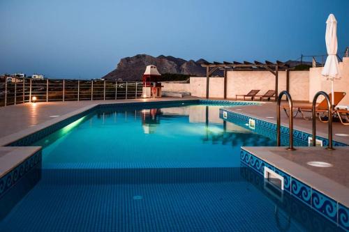 a swimming pool with blue water in a building at Seascape in Tersanas