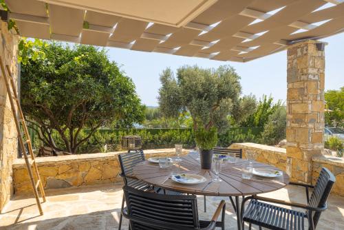 a patio with a table and chairs under a pergola at Chariclea Villas Retreat in Samos