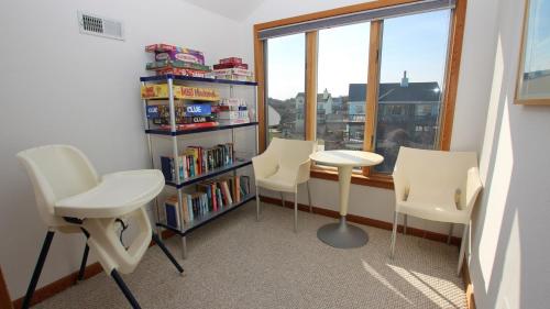a room with three chairs and a book shelf with books at Semi-Oceanfront, Private Pool, Hot Tub, Close to Beach Access, GF2, Touch of Grey in Sanderling
