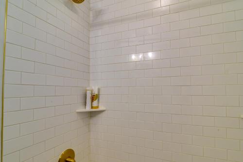 a bathroom with white tiled walls and a shelf at Luxurious Morgantown Retreat with Stunning Views! in Morgantown