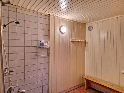 a bathroom with a shower and a bench in it at Püha Guesthouse in Püha