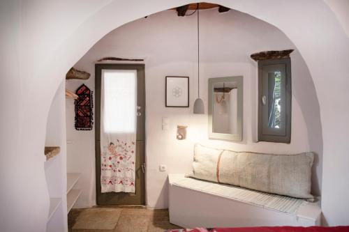 a room with an archway with a bench and a door at Under The Linden Tree Tinos in Xinára