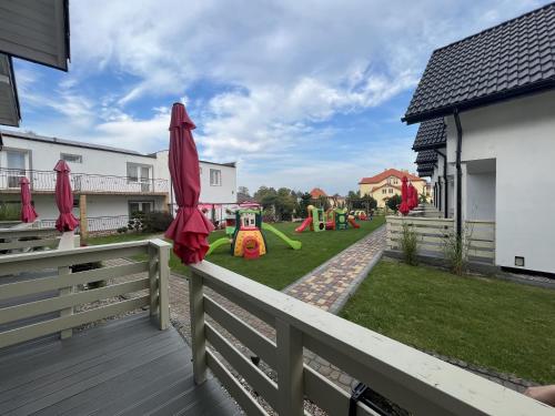 uitzicht op een speeltuin vanaf het terras van een huis bij Domki Słoneczka in Sarbinowo