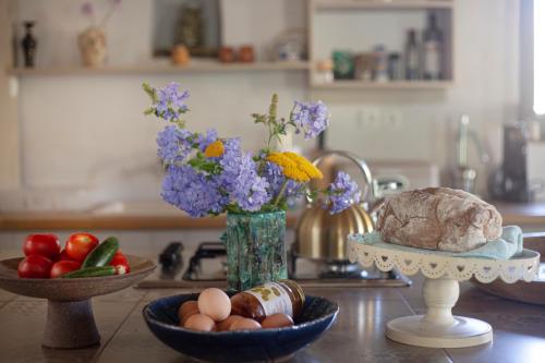 a kitchen counter with bowls of food and a vase of flowers at Under The Linden Tree Tinos in Xinára