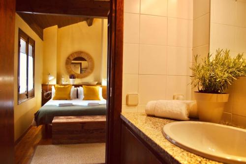 a bathroom with a bed and a sink and a tub at La Cabaña de Llívia, Cerdanya, Puigcerdà. in Llivia