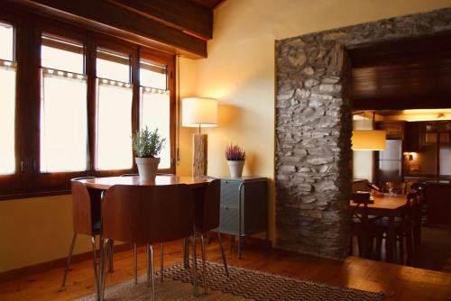 a dining room with a table and a stone wall at La Cabaña de Llívia, Cerdanya, Puigcerdà. in Llivia