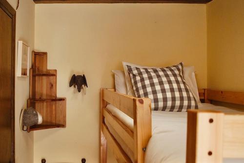 a bedroom with a bed with a checkered pillow at La Cabaña de Llívia, Cerdanya, Puigcerdà. in Llivia