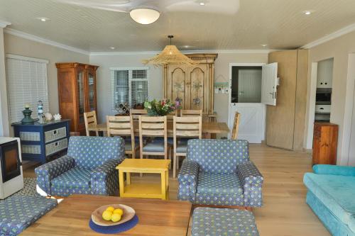 a living room with a couch and a dining room at Oupa se Pitte in Herolds Bay
