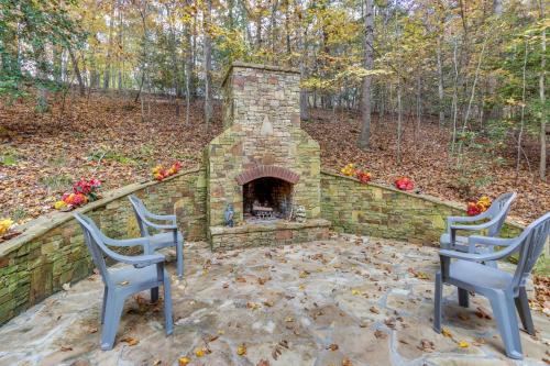 two chairs and a brick fireplace in a yard at Quiet Murphy Hideaway with Decks and Outdoor Fireplace in Murphy