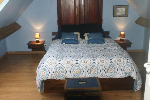 una camera da letto con un grande letto con due comodini di Le p'tit hameau de Sey a Quettehou