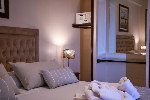 a bedroom with a bed with a stuffed animal on it at Hotel Catalinas Tucuman in San Miguel de Tucumán
