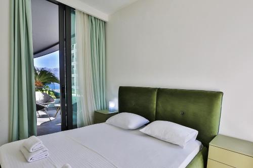 Schlafzimmer mit einem Bett und Blick auf eine Terrasse in der Unterkunft Royal Gardens Paradise in Budva
