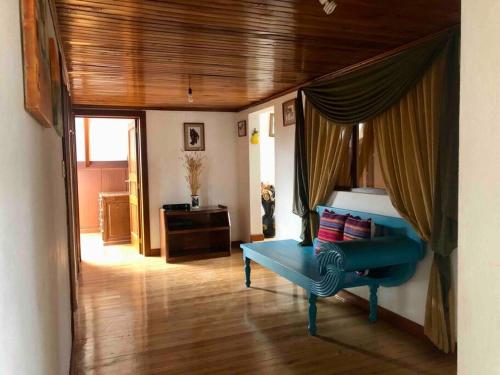 uma sala de estar com um sofá azul e um quarto em Cosita Linda - Departamento familiar 3 hab. em Cuenca