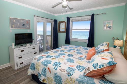 a bedroom with a bed and a television and a window at OCEANFRONT, Community Pool and beach walkway! KD220, Feelin Nauti in Kill Devil Hills