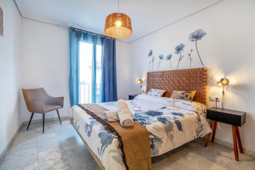 a bedroom with a bed and a chair at Zafiro Apartment&Parking in the historical centre in Córdoba