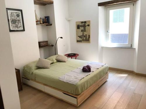1 dormitorio con 1 cama en una habitación con ventana en Orbetellove, en Orbetello
