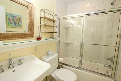 a bathroom with a shower and a toilet and a sink at OCEANFRONT, Community Pool and beach walkway! KD220, Feelin Nauti in Kill Devil Hills