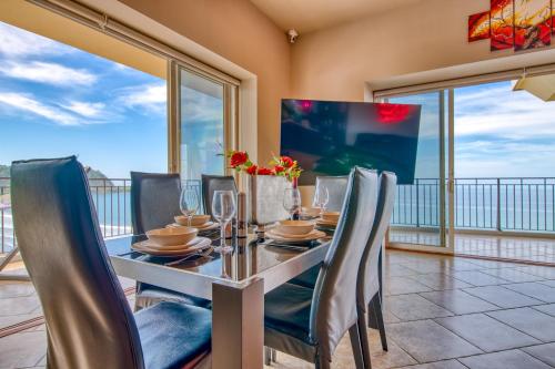 comedor con mesa, sillas y ventanas en SecretJaco - Luxury Beach Front Penthouse with Pool & Jacuzzi, en Jacó