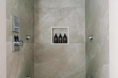 a bathroom with a shower with three bottles in it at Royal Berkshire in Ascot